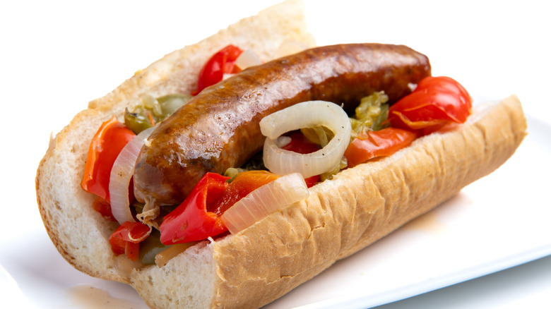 A sandwich with Italian sausage, onions, and peppers