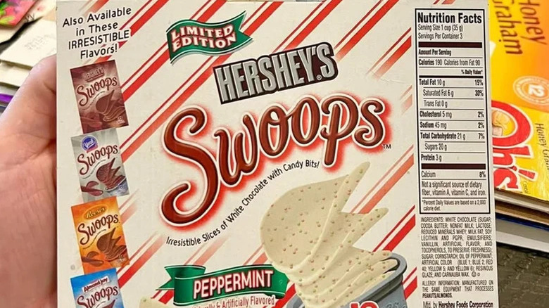 A hand holding a Hershey's Swoops package