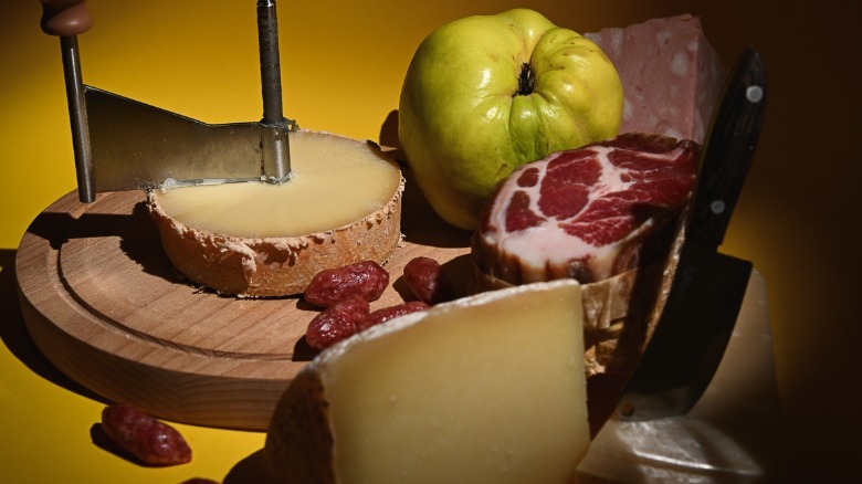 Cheese, meats, and fruits on a wooden board