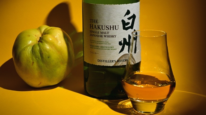 Glass and bottle of Japanese whisky with fruit