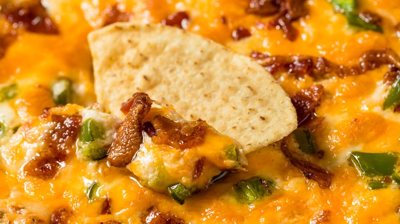 tortilla chip in bacon queso