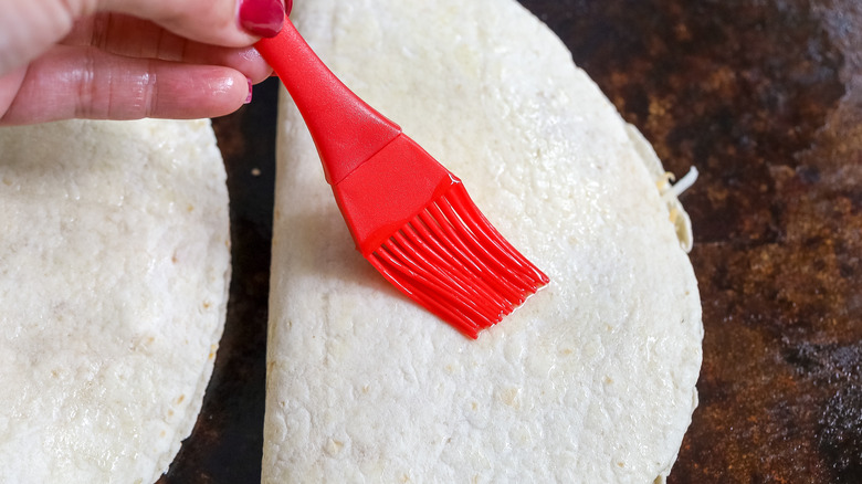 the top of a tortilla being brushed with olive oil