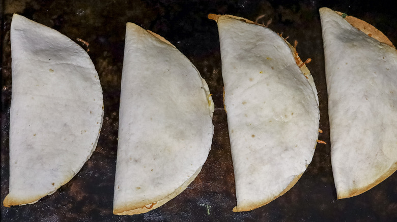 partially baked quesadillas on a pan