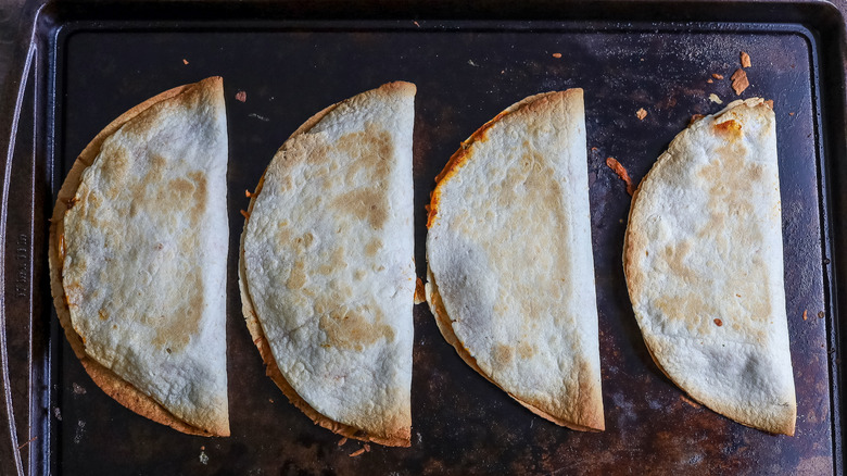 fully baked quesadillas on a baking sheet