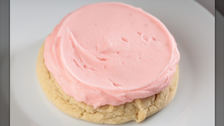 A sugar cookie with pink frosting