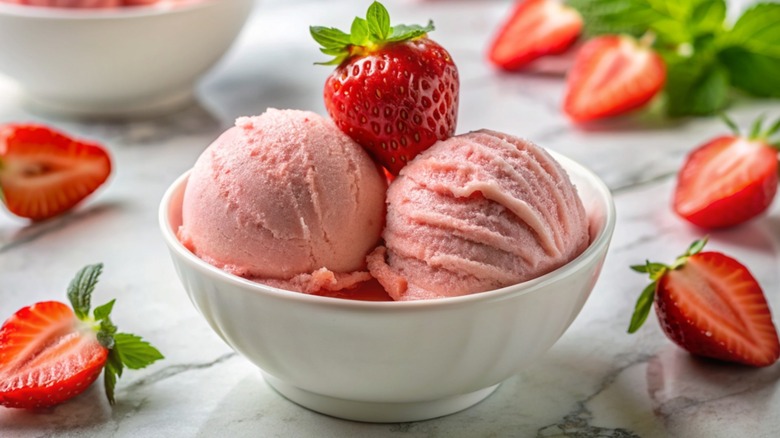 A bowl of strawberry ice cream with strawberries