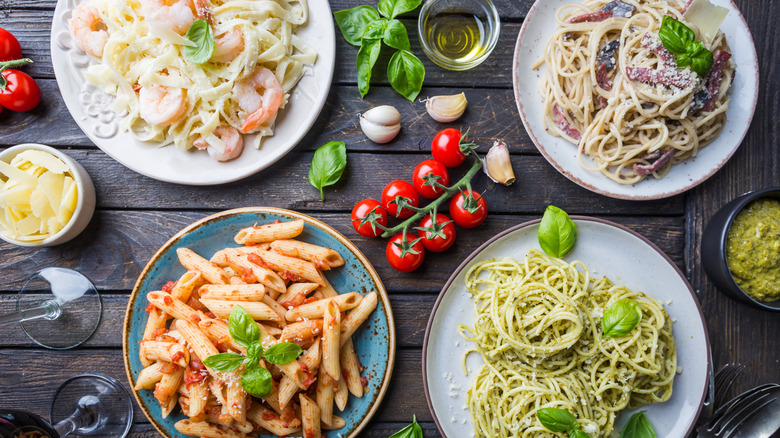 Overview of four different plated pasta dishes with ingredients