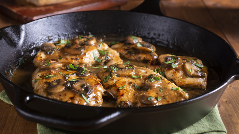 chicken cooking in cast iron pan