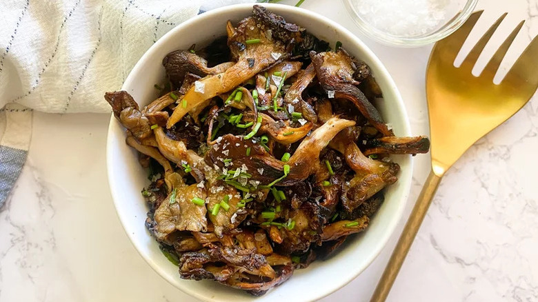 Bowl of mushrooms with garnish and seasonings