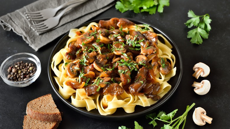 beef stroganoff surrounded by raw ingredients