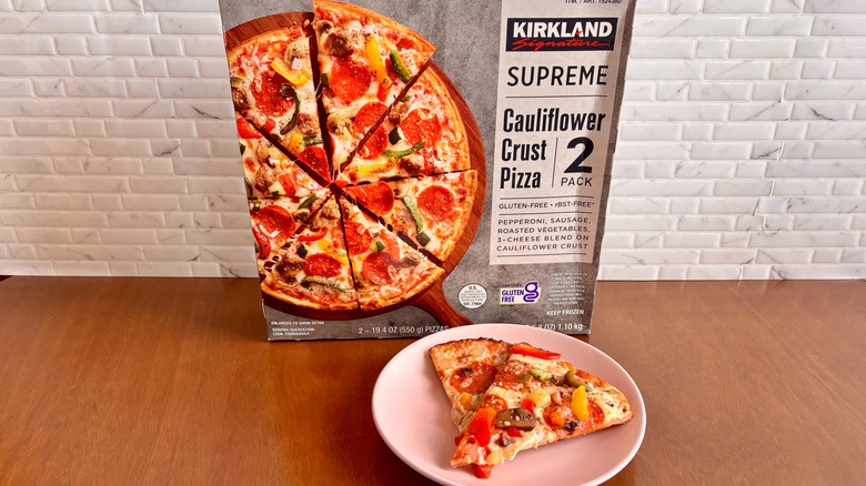 Kirkland supreme cauliflower crust pizza box next to pizza slices on plate