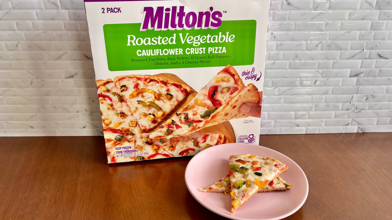 Milton's vegetable cauliflower crust pizza box next to slices of pizza on plate