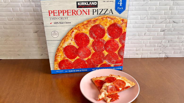 Kirkland pepperoni pizza box next to pepperoni pizza slices on plate