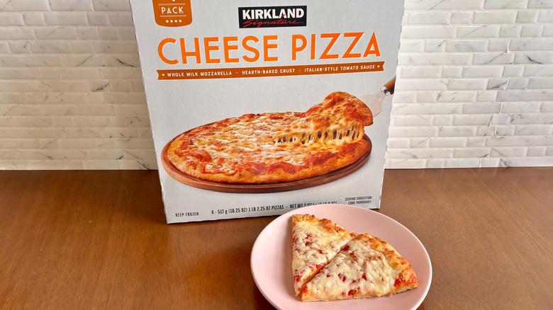 Kirkland cheese pizza box next to cheese pizza slices on plate