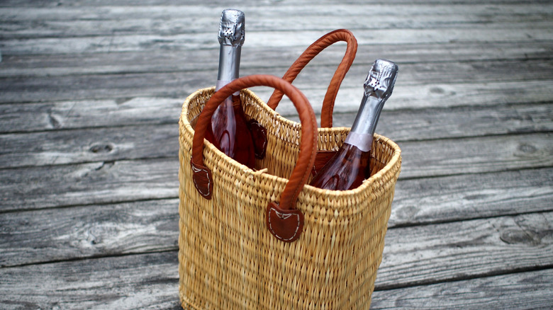 wicker purse containing two bottles of sparkling wine