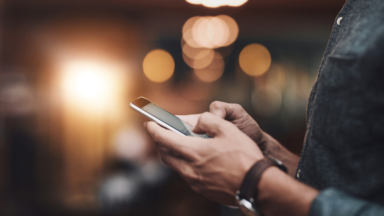 man dialing a number on his smartphone