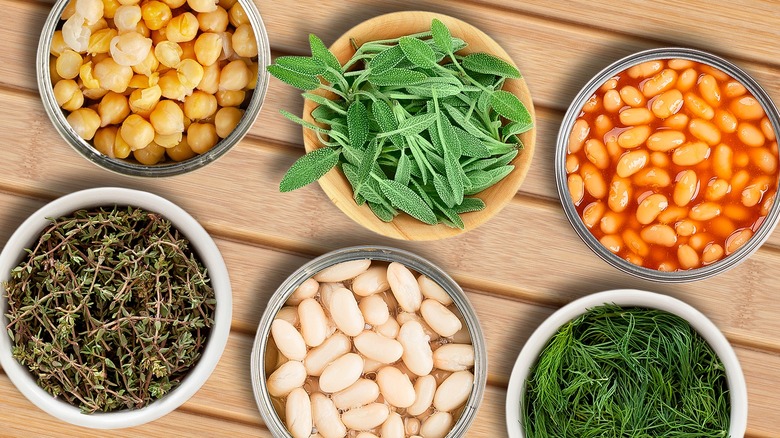 canned beans arranged with bowls of herbs