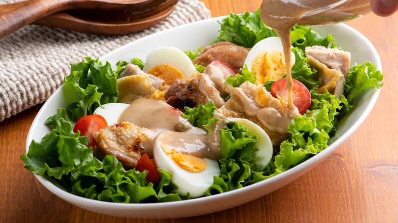 adding dressing to chicken salad