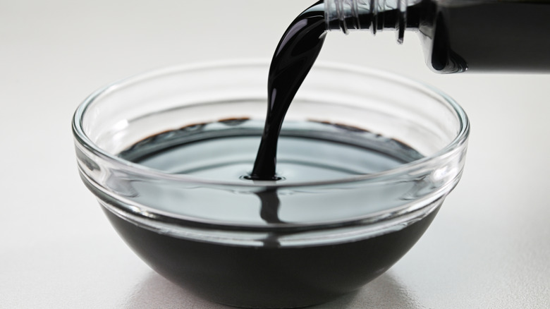 pouring soy sauce into glass bowl