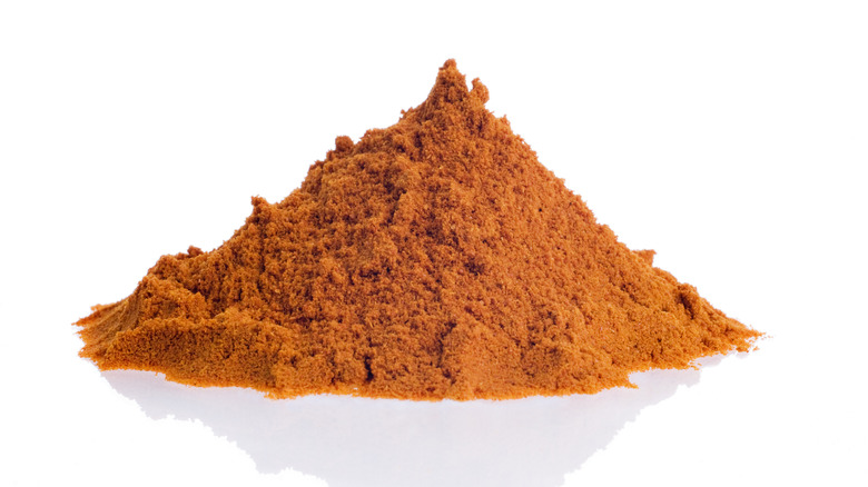 Pile of ground red paprika on a white background