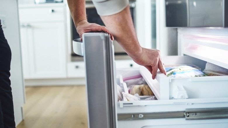 man opening a freezer drawer