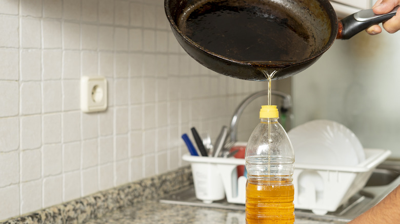 pouring oil into plastic bottle