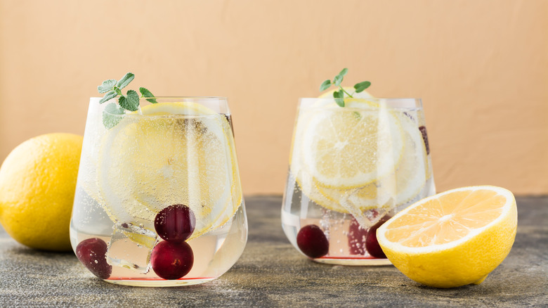 Two glasses of carbonated water with lemon and cherries