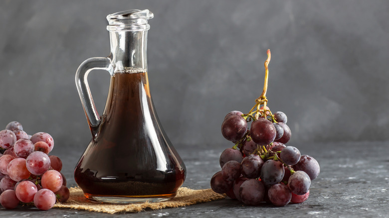 glass bottle of balsamic vinegar with grapes