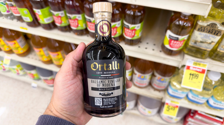 person holding balsamic vinegar in supermarket