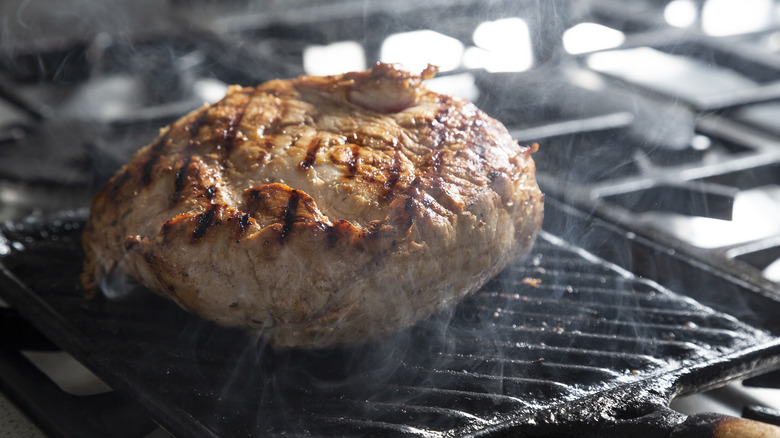 pork shoulder cooking on grill