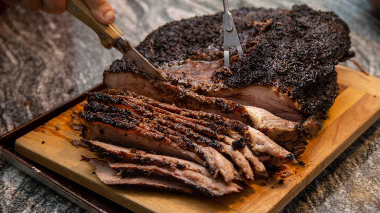 slicing smoked brisket on cutting board