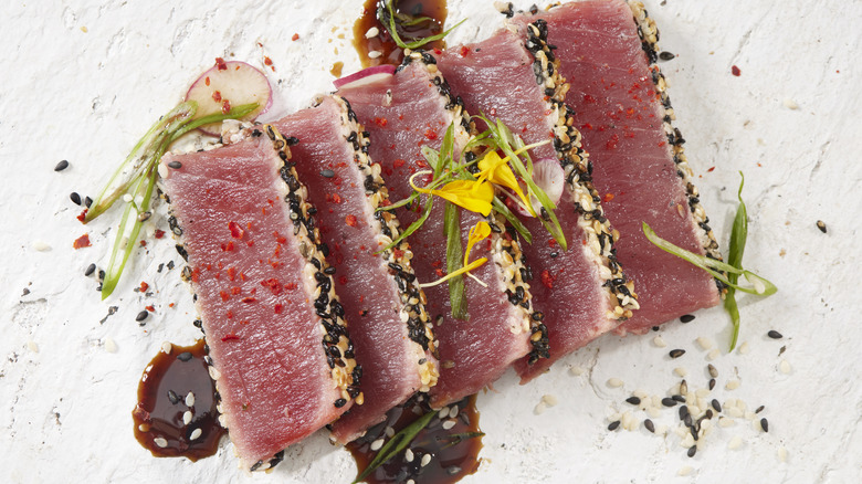 Tataki tuna on a plate with sprouts and sauce