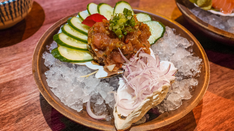 Tuna namero with cucumbers and vegetables in wooden bowl