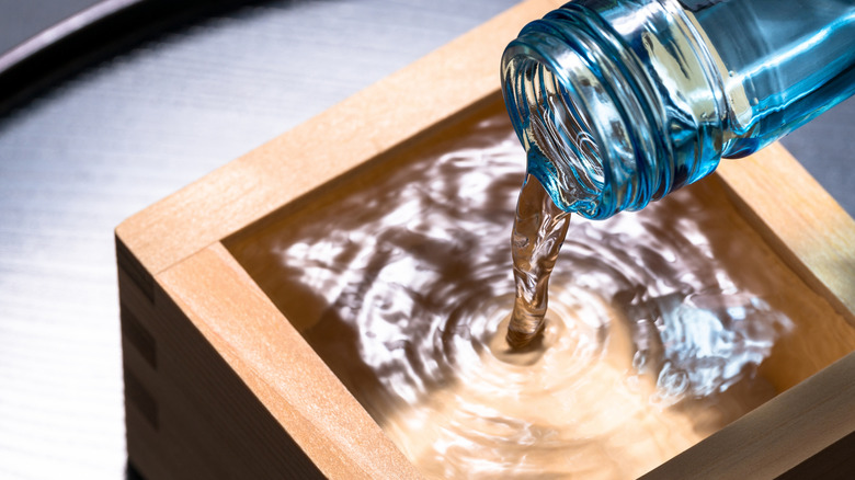 Clear sake poured into wooded cup