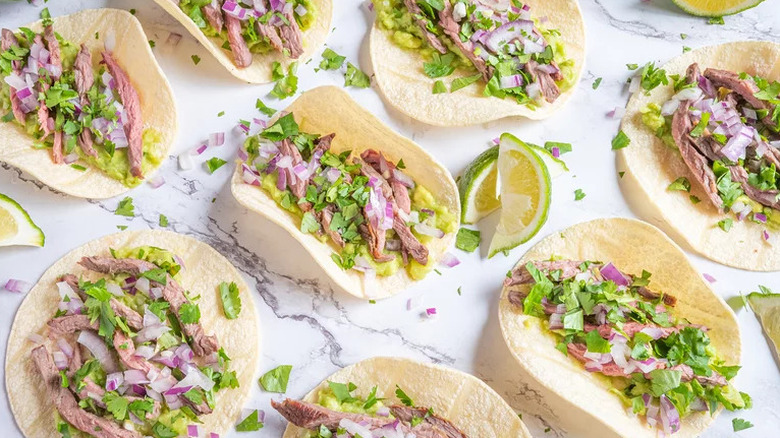 Beef tacos with lime wedges