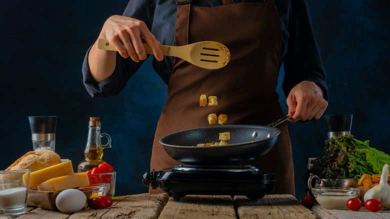 tossing croutons in skillet