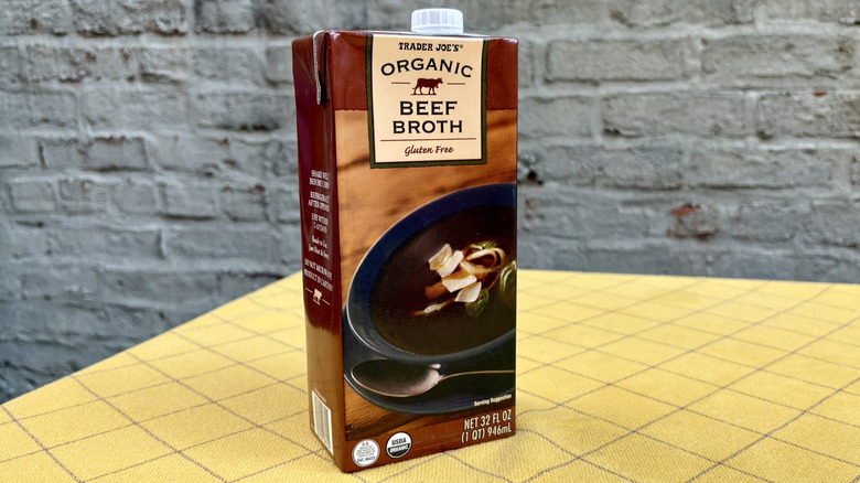 Trader Joe's beef broth carton set on a yellow tablecloth