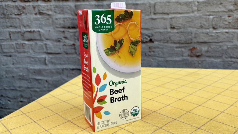 Whole Foods 365 beef broth carton sitting on a yellow tablecloth