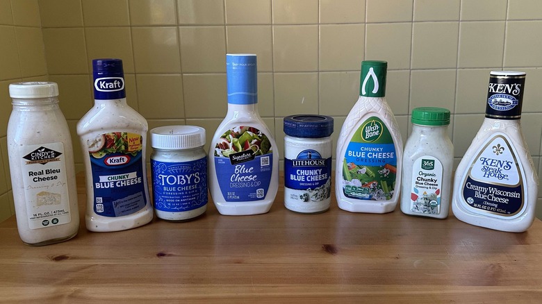 Blue cheese dressing bottles lined up on a wood table