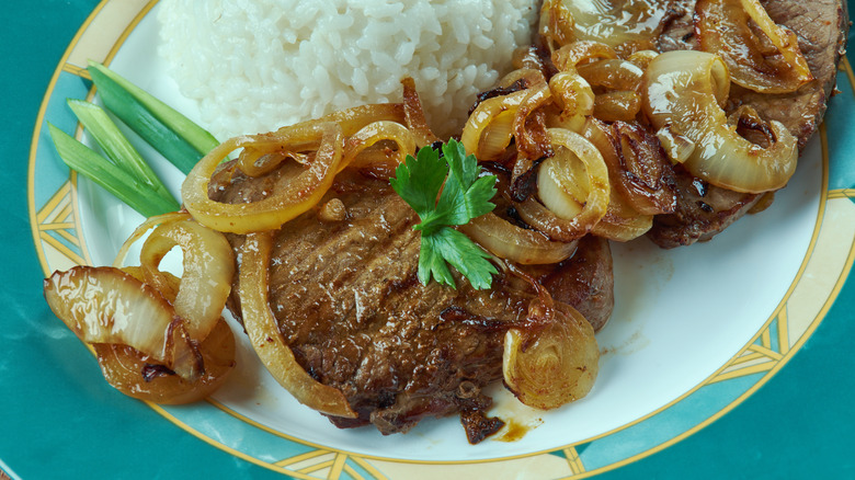 Sliced Cuban steak with onions served with rice