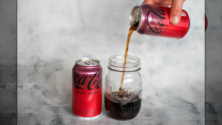 Pouring cherry Coke Zero can into a Mason jar