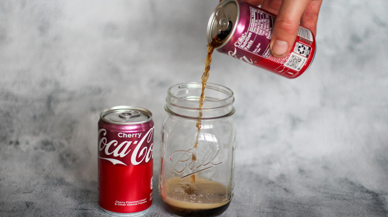 Pouring Cherry Coke can into a Mason jar