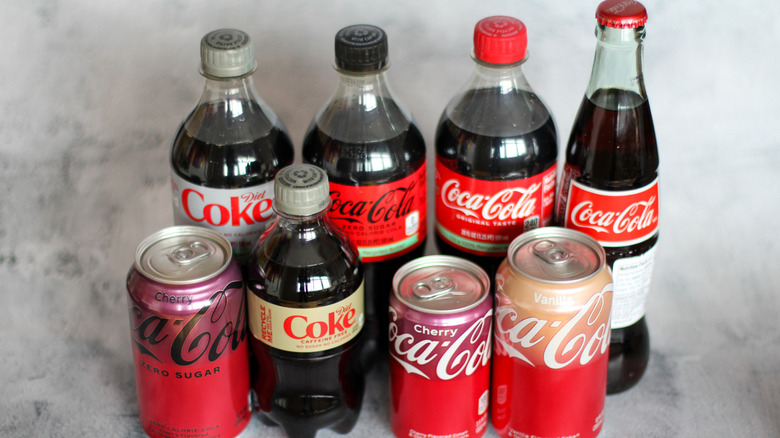 Eight Coca-Cola products on a gray background