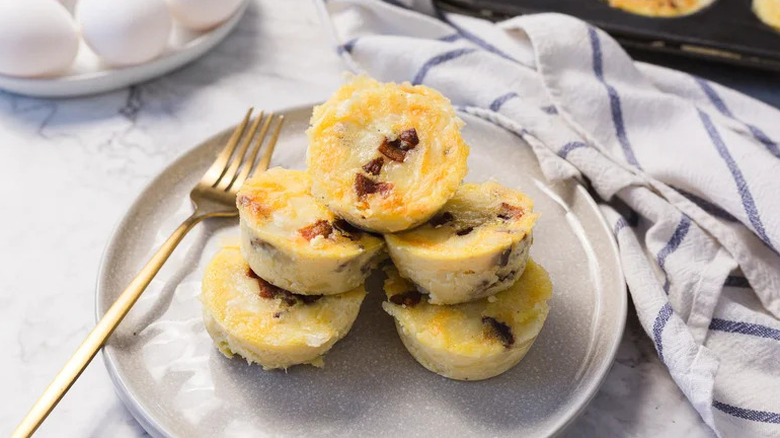 Copycat Starbucks bacon and egg Gruyère bites stacked on white plate with gold fork