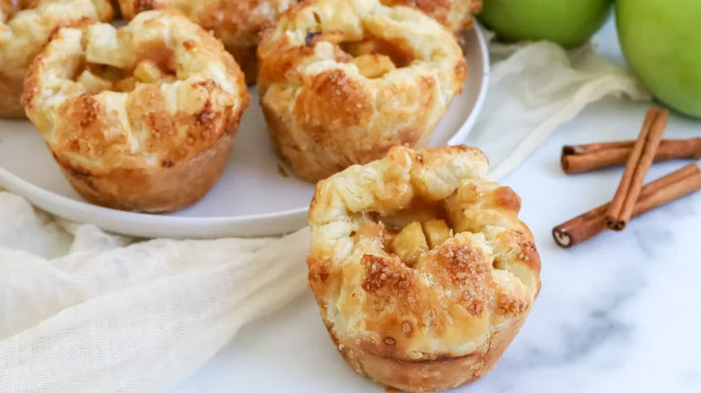 Copycat Starbucks baked apple croissants on white plate with cinnamon sticks