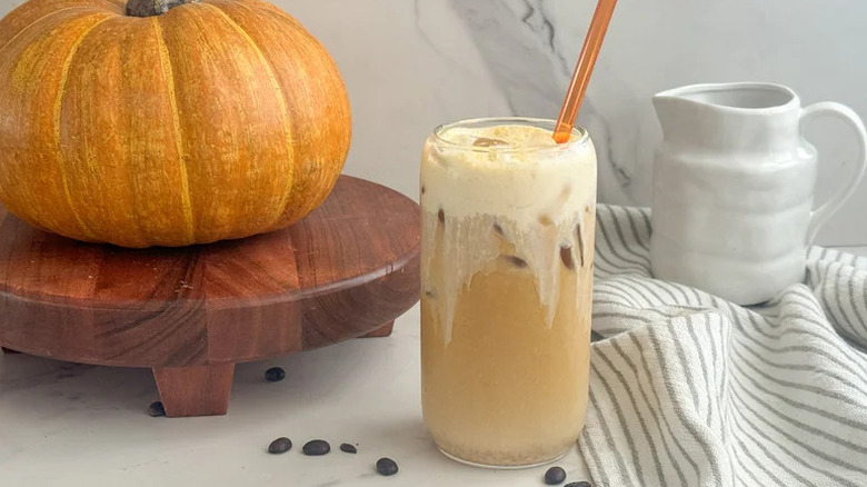 DIY Starbucks pumpkin cream cold brew on white counter with pumpkin in background