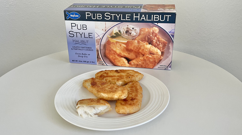 Neptune pub style halibut filets sit on a plate with the product's packaging behind it.