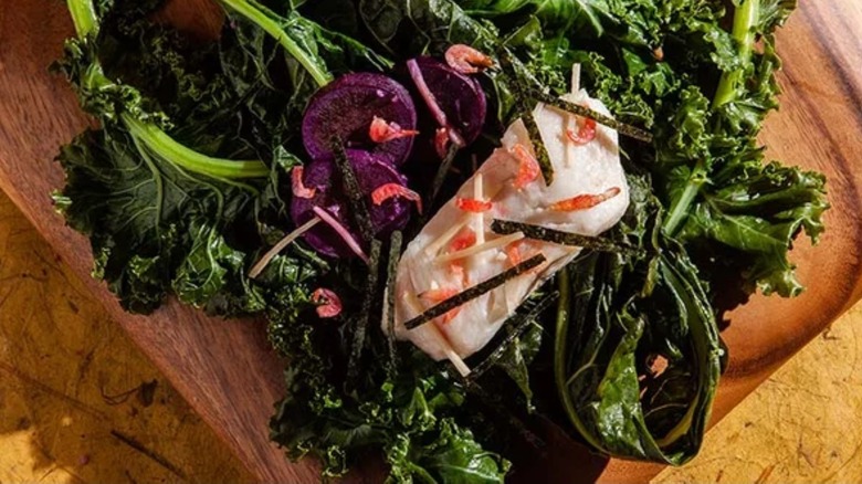 cod garnished with nori over kale