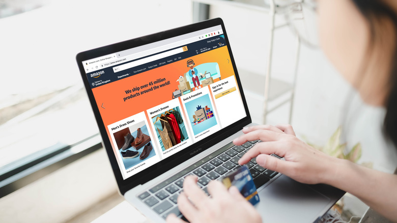 Person using Amazon's website on a laptop to do online shopping