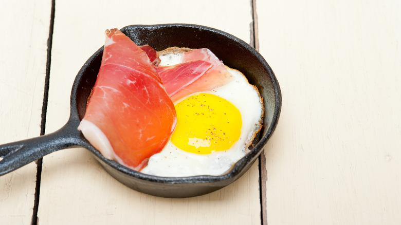 Fried egg in a mini cast iron pan with speck ham.